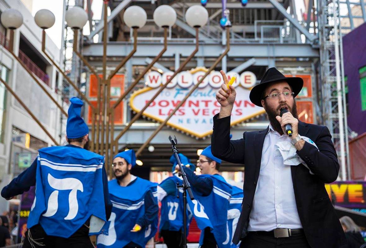 Rabbi Levi Harlig addresses the crowd during a celebration of the first night of Hanukkah with ...