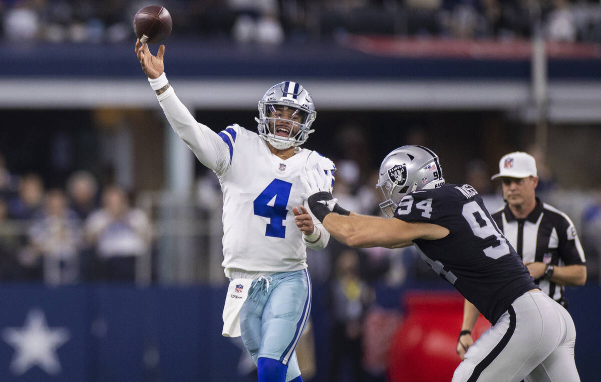 Dallas Cowboys quarterback Dak Prescott (4) just gets a pass away with pressure from Raiders de ...
