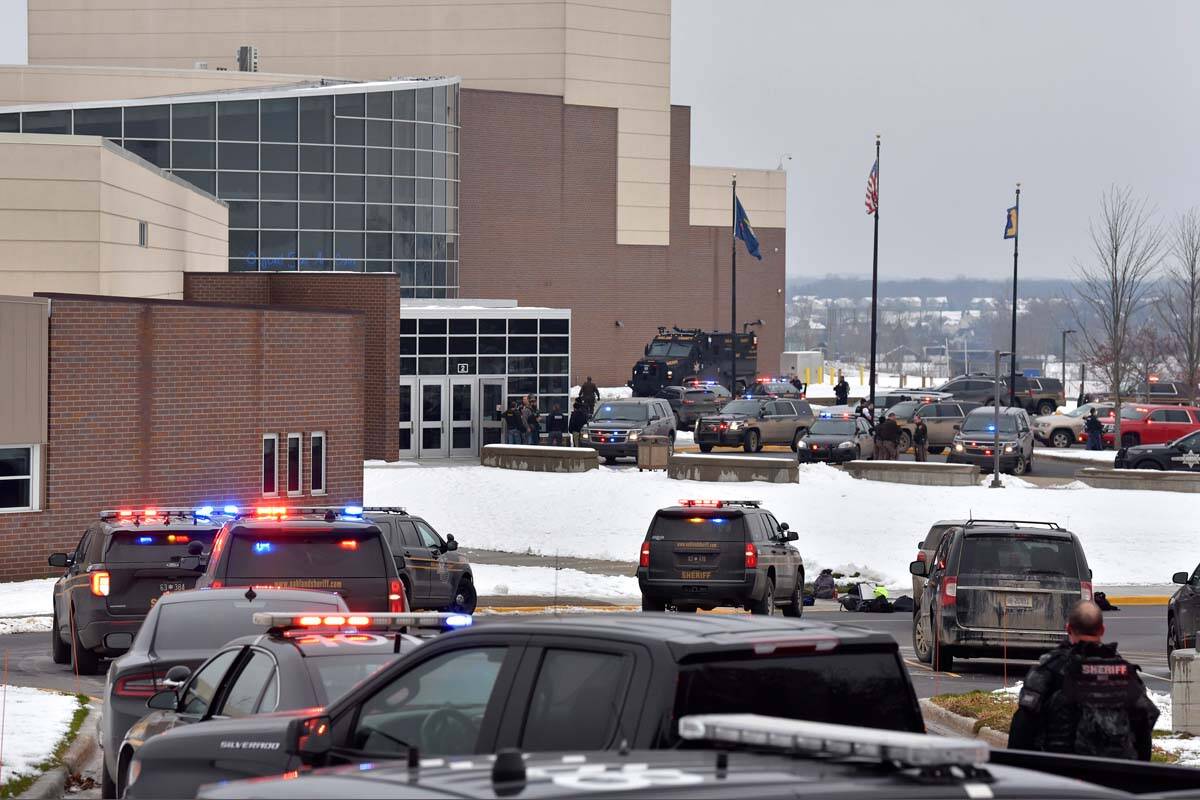 Dozens of police, fire, and EMS personnel work on the scene of a shooting at Oxford High School ...