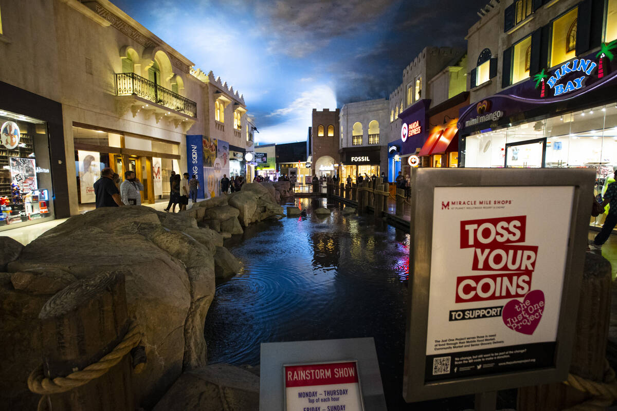 A sign promoting coins to be tossed during the rainstorm show is seen at the Miracle Mile Shops ...