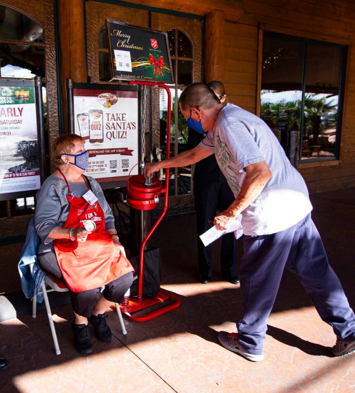 Dan Lee, of Henderson, makes a donation while being greeted by Salvation Army bell ringer Anita ...