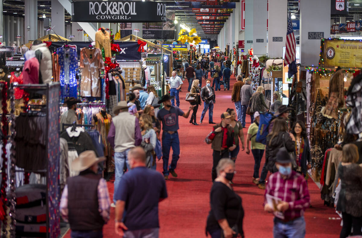 Shoppers make their way up a main aisle during the opening night of the Cowboy Channel Cowboy C ...