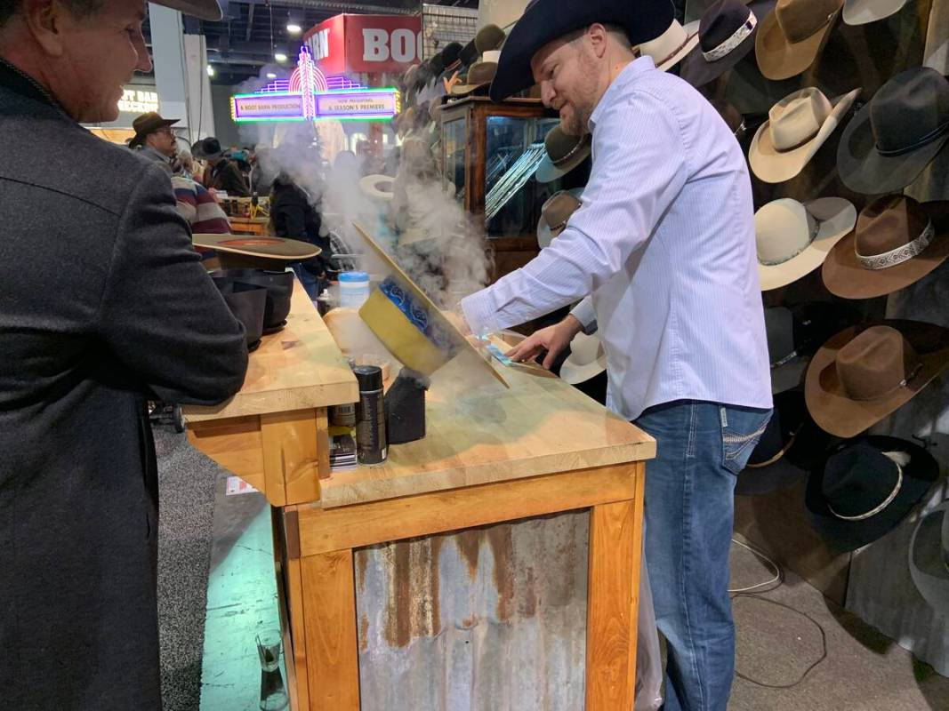 Custom hat maker Braydan Shaw plies his trade as customer Mitch Clum looks on at the Burns Hats ...