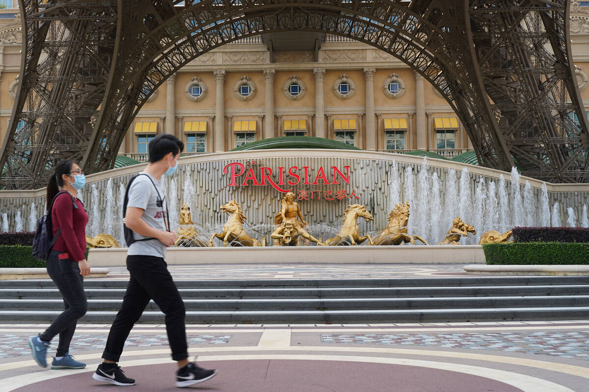 People walk past a replica Eiffel Tower outside the Parisian Macao on April 10, 2020. (Inside A ...