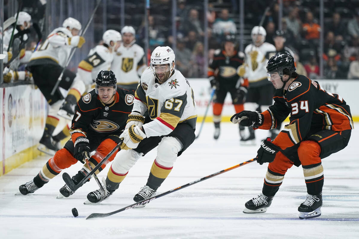 Vegas Golden Knights' Max Pacioretty, center, moves the puck under pressure by Anaheim Ducks' J ...