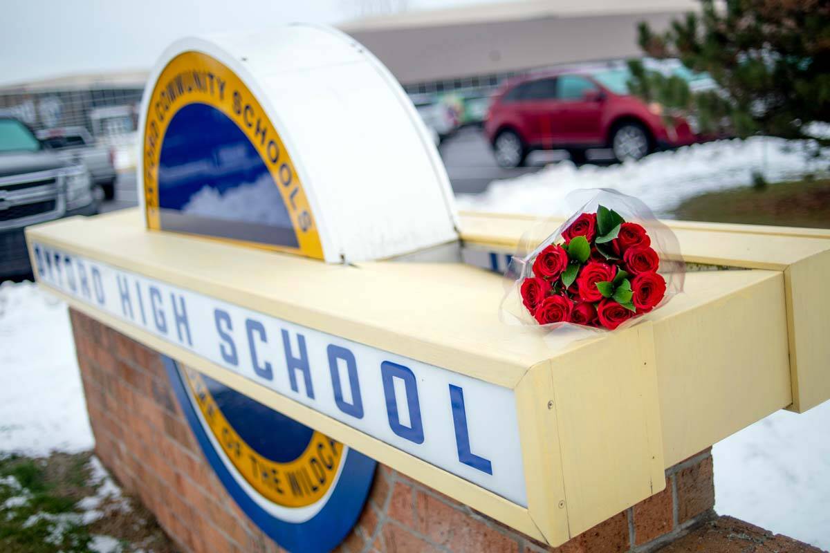 A bouquet of roses sits on a sign outside of Oxford High School on the day after the school sho ...