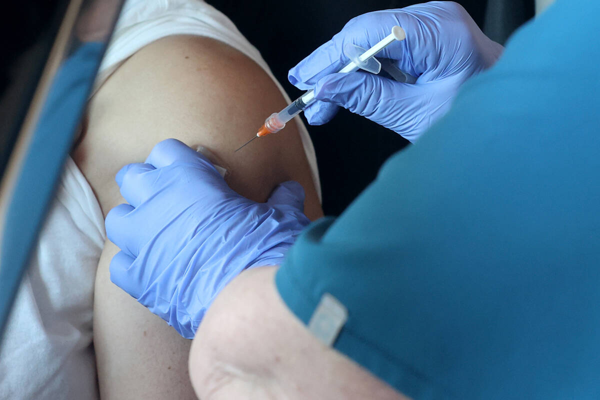 Teresa Woods gives a shot during a drive-thru COVID-19 vaccine clinic in the Bronze Lot at the ...