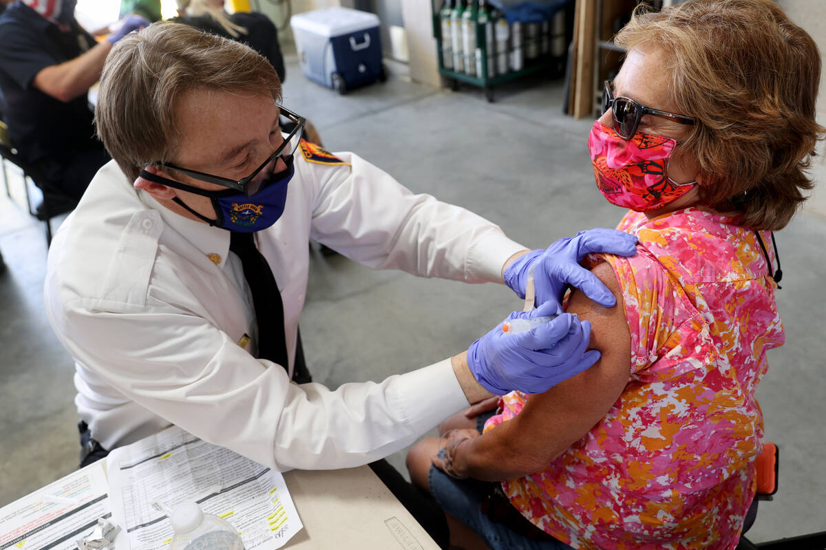 Clark County Fire Department Chief John Steinbeck gives a COVID-19 vaccine to Lynn Mendez, 58, ...
