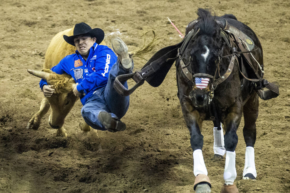 Dirk Tavenner of Rigby, ID., leaves his horse in Steer Wrestling to tie for first place during ...