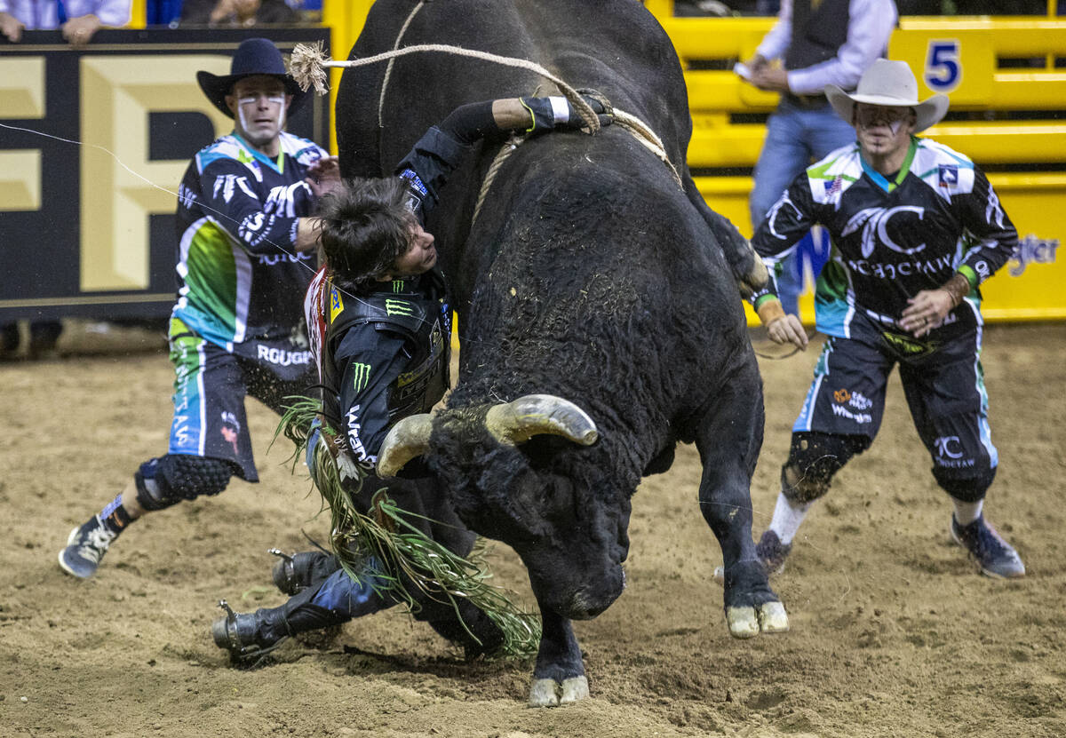 J.B. Mauney of Cotulla, TX., is dragged by Johnny Thunder in Bull Riding as bullfighters move i ...