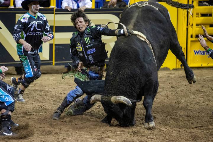 J.B. Mauney of Cotulla, TX., is dragged by Johnny Thunder in Bull Riding as bullfighters move i ...