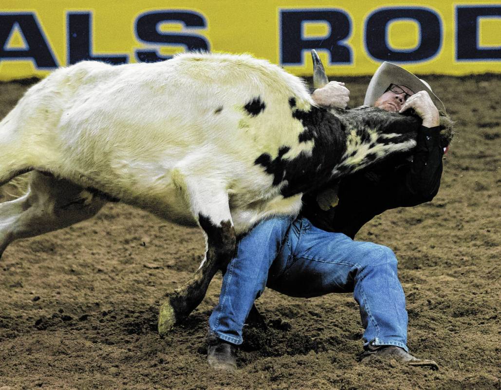 Stockton Graves of Alva, Okla., in steer wrestling during the fourth round of the Wrangler Nati ...