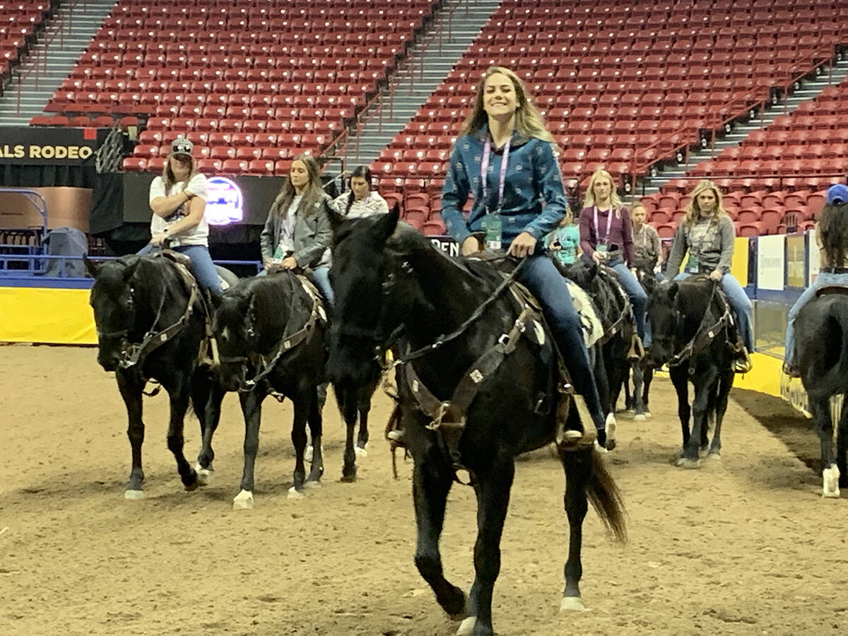 Members of the NFR Flag Girls trot their horses around the Thomas & Mack Center floor during a ...