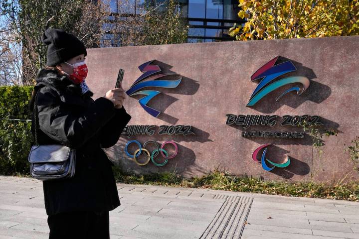 A visitor to the Shougang Park walks past the logos for the Beijing Winter Olympics and Paralym ...