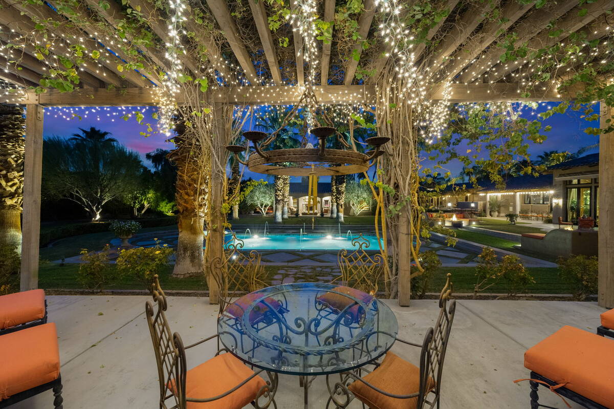 The pergola features natural wood beams draped with vines. (BHHS)