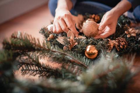 Gold balls and gold-painted pine cones create a festive wreath. (Getty Images)