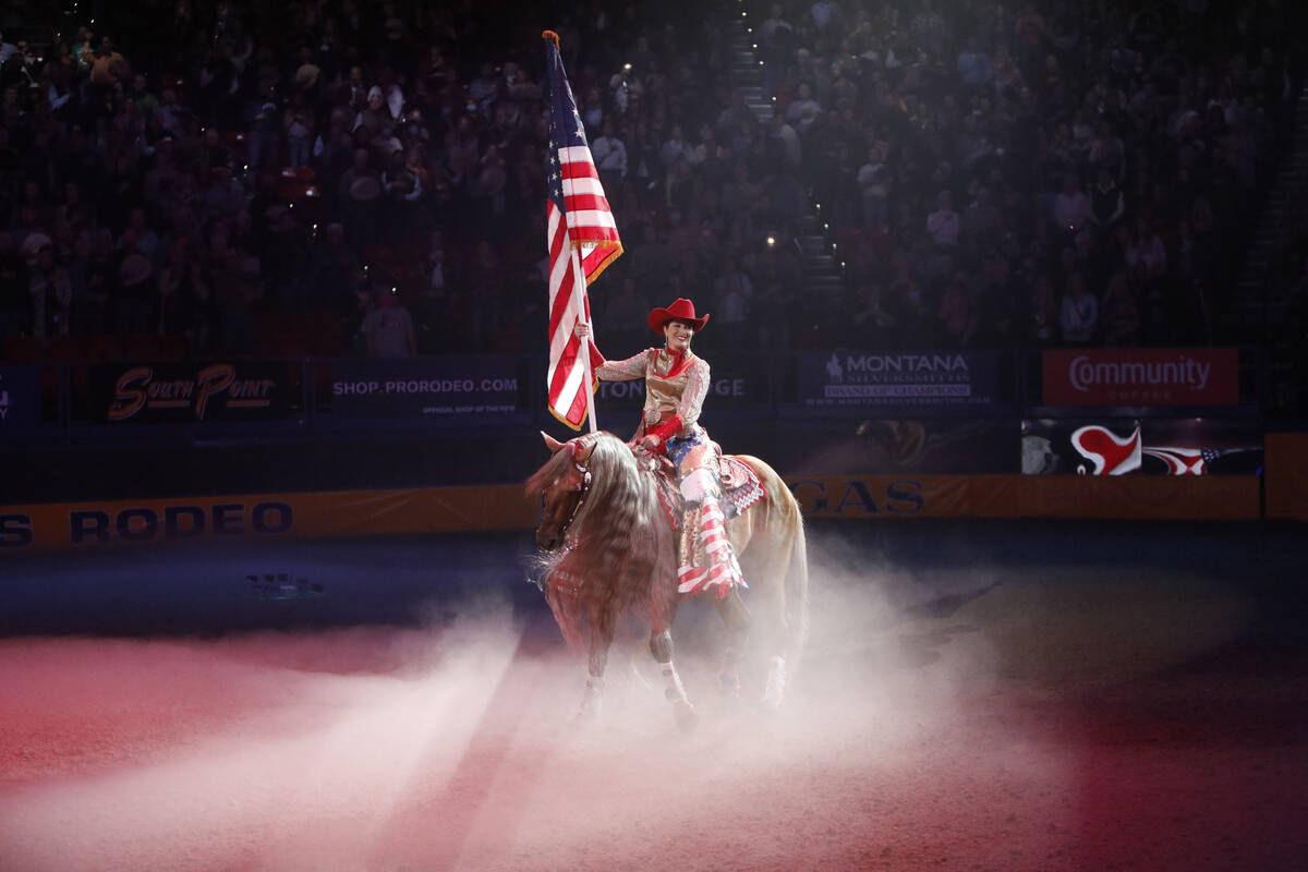 Justine Garcilazo holds an American flag during the national anthem before the seventh go-round ...