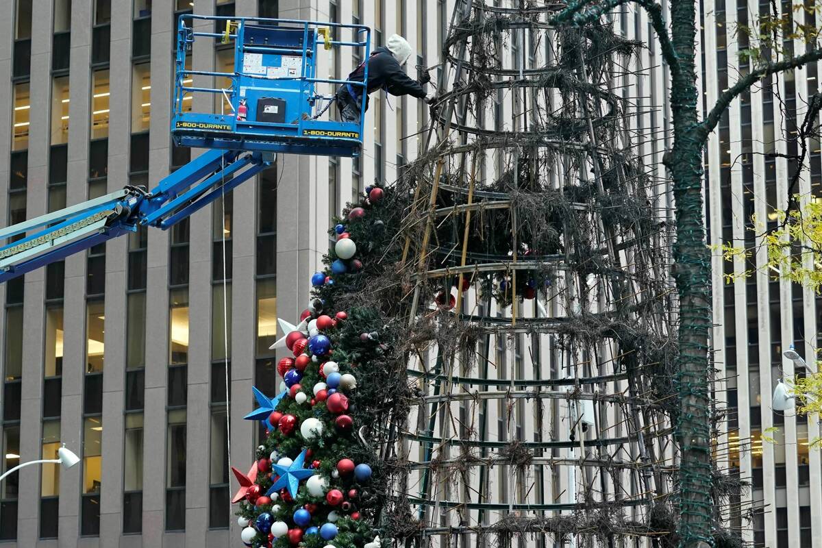 A worker disassembles a Christmas tree outside Fox News headquarters, in New York, Wednesday, D ...