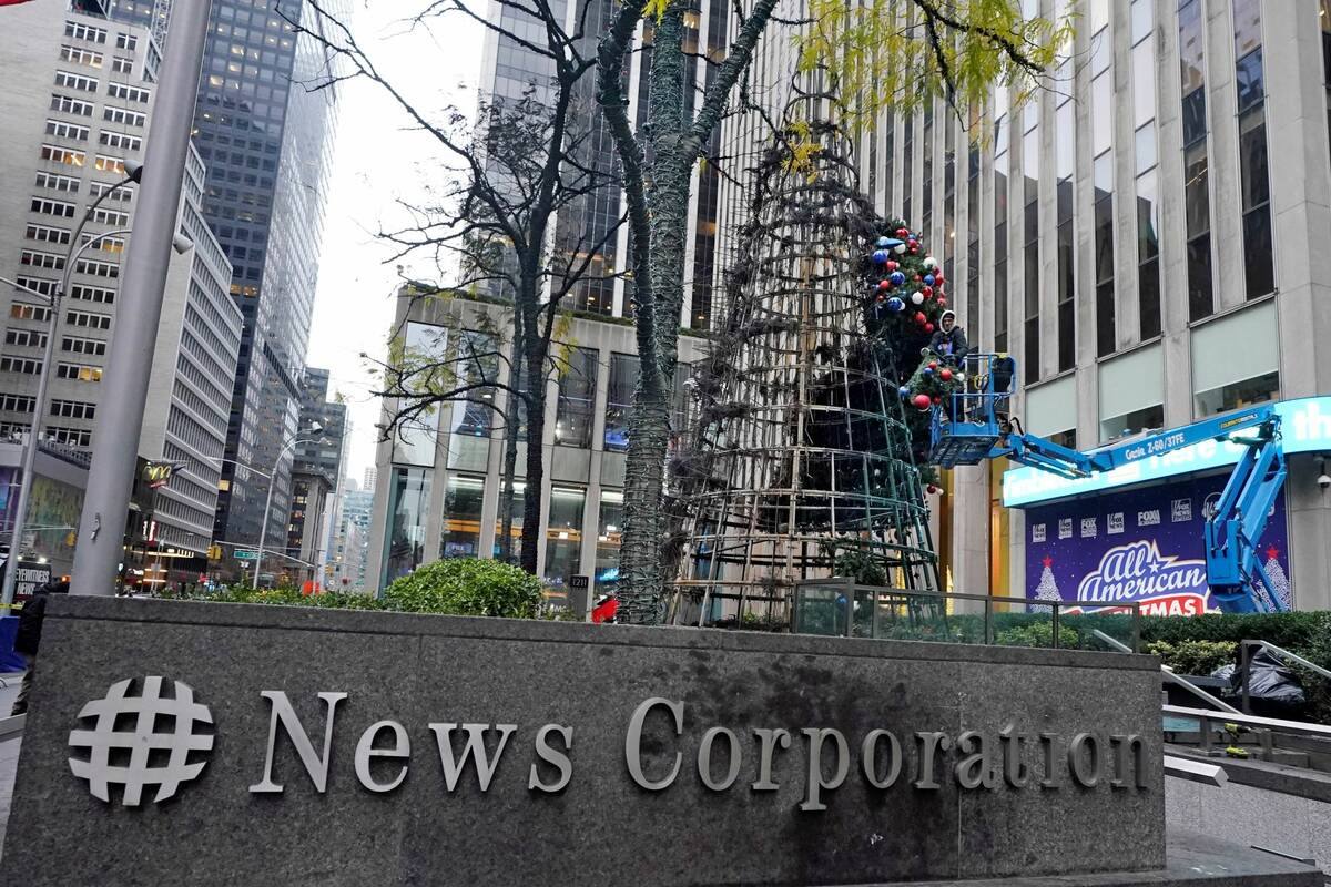 A worker disassembles a Christmas tree outside Fox News headquarters, in New York, Wednesday, D ...