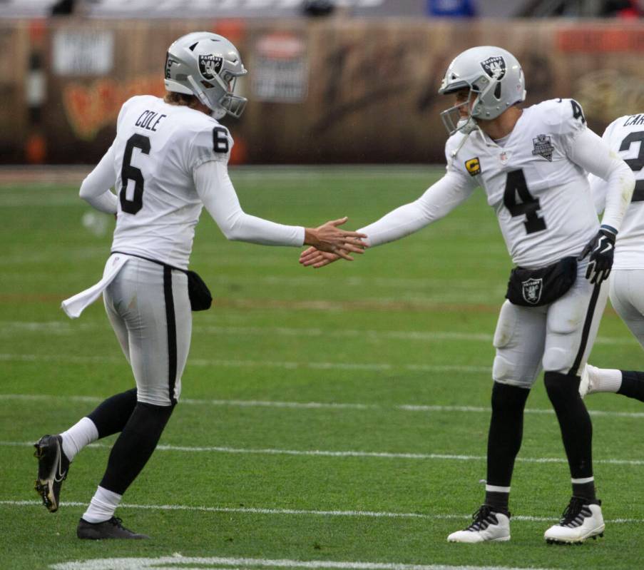 Las Vegas Raiders quarterback Derek Carr (4) congratulates punter AJ Cole after kicker Daniel C ...