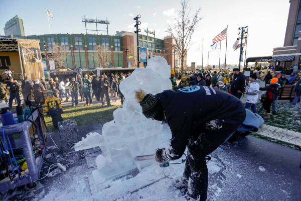 Fans tailgate outside Lambeau Field before an NFL football game between the Green Bay Packers a ...