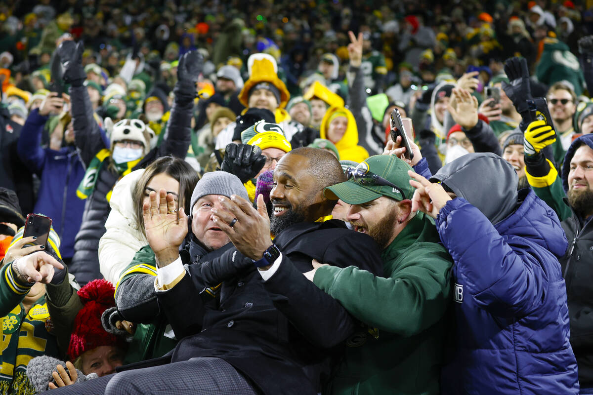 Former Green Bay Packer and HOF member Charles Woodson does a Lambeau leap with fans during hal ...