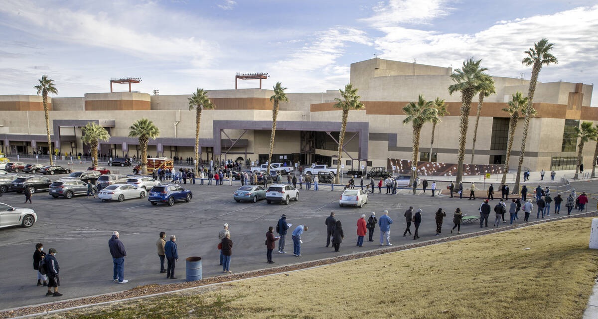 People wait in a long line in the parking lot at the Cashman Center for COVID-19 vaccinations o ...