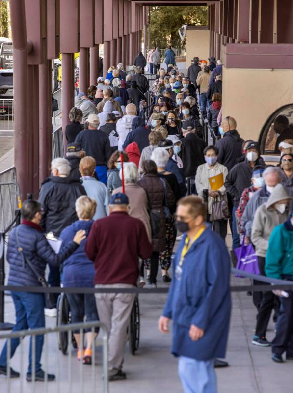 People move along while weaving in line to enter the Cashman Center for COVID-19 vaccinations o ...