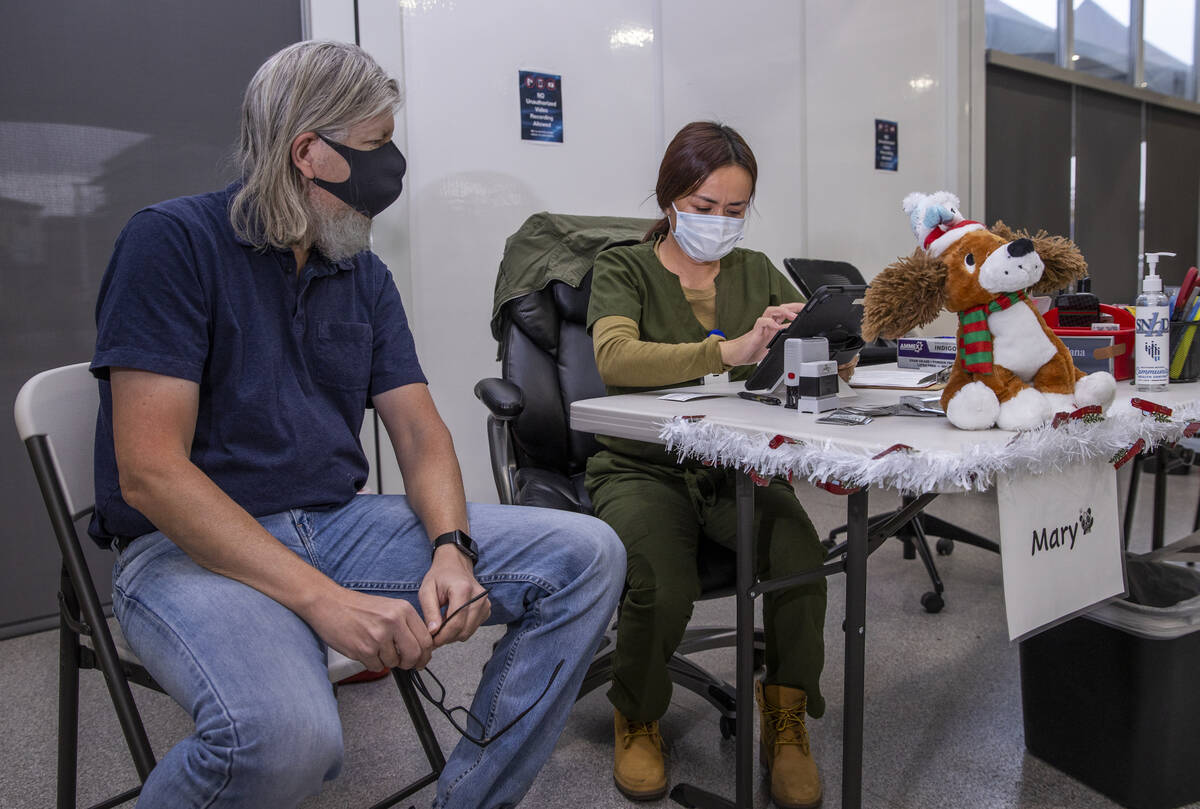 Michael Homa, left, confers with Mary Aldana to ensure his paperwork is correct while in the CO ...