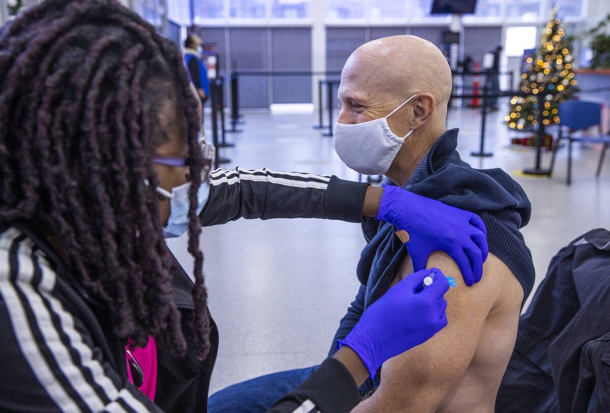 Adwoa Fosu gives a shot to Harrison Kerschner in the COVID-19 vaccination clinic at the Souther ...