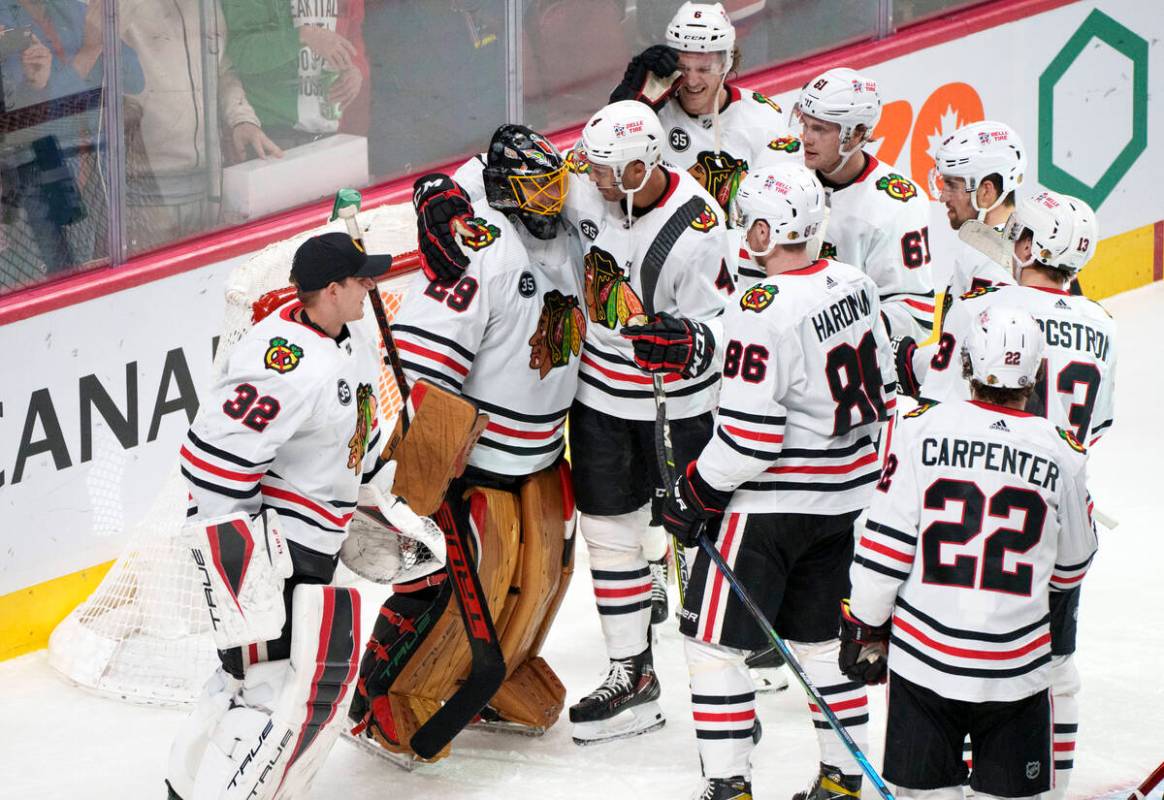 Teammates gather around Chicago Blackhawks goaltender Marc-Andre Fleury after recording his 500 ...