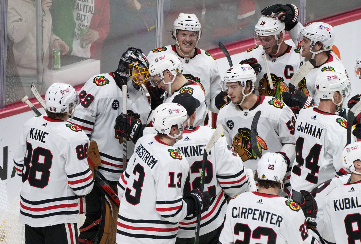 Teammates gather around Chicago Blackhawks goaltender Marc-Andre Fleury (29) after recording hi ...