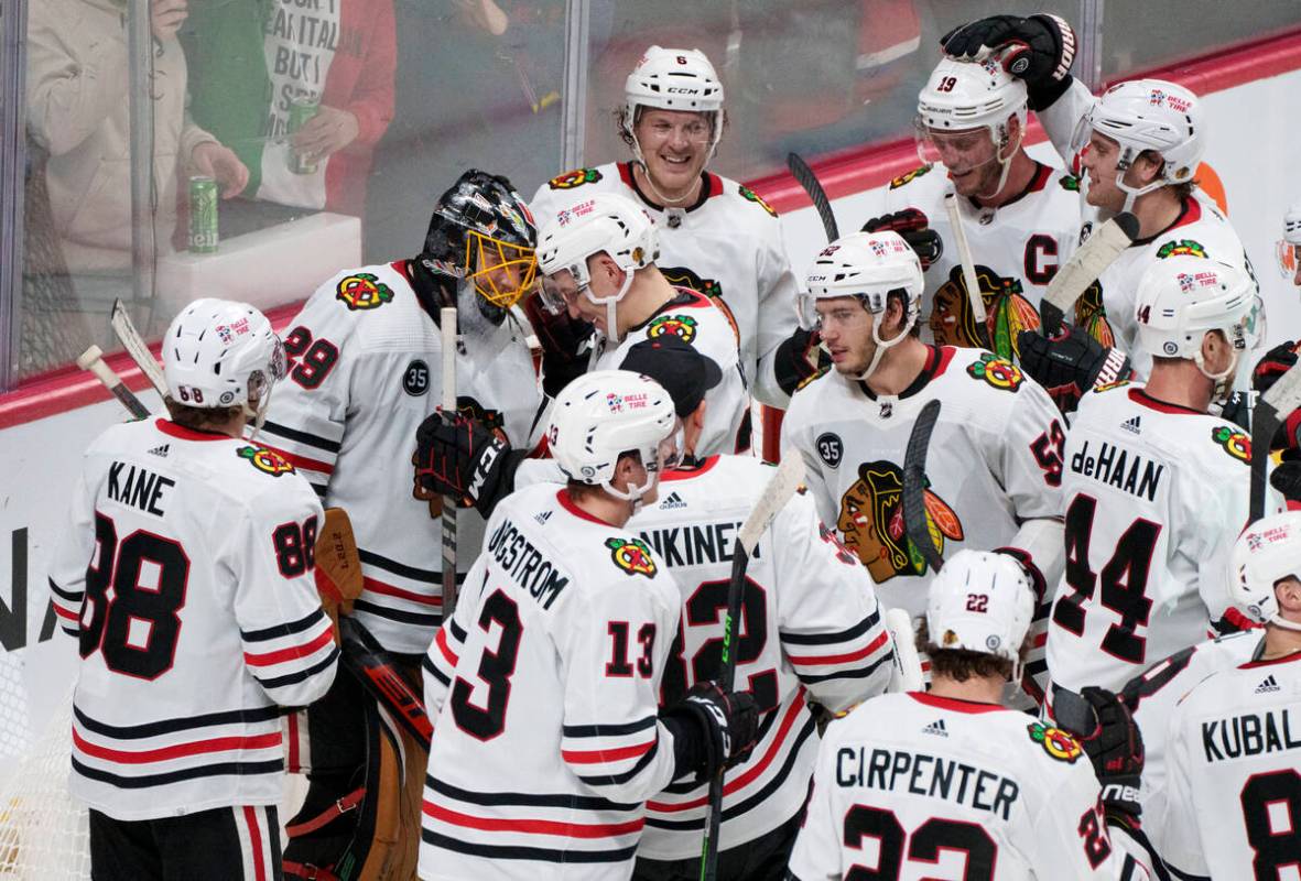 Teammates gather around Chicago Blackhawks goaltender Marc-Andre Fleury (29) after recording hi ...