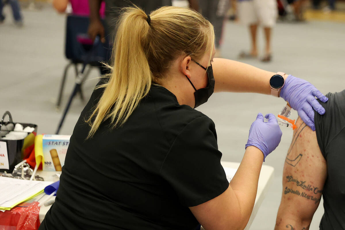 Steve Cancino of Las Vegas, right, receives his second dose of the Moderna COVID-19 vaccine fro ...