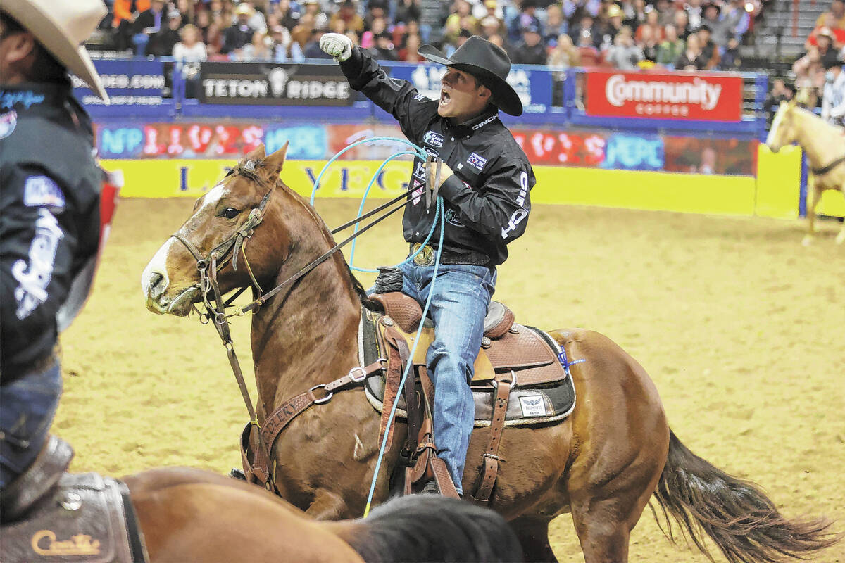 Logan Medlin of Tatum, N.M., celebrates after competing in the team roping event during the nin ...