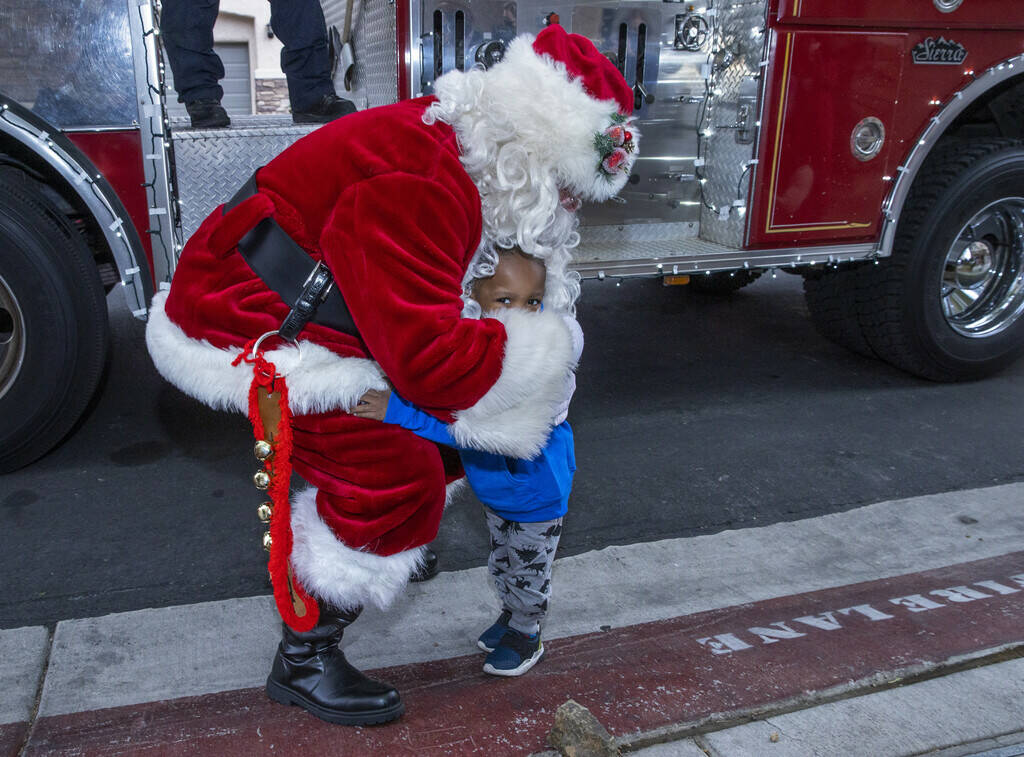 Aayden Hobbs, 3, a heart transplant recipient, hugs Santa at his home while getting his wish fo ...