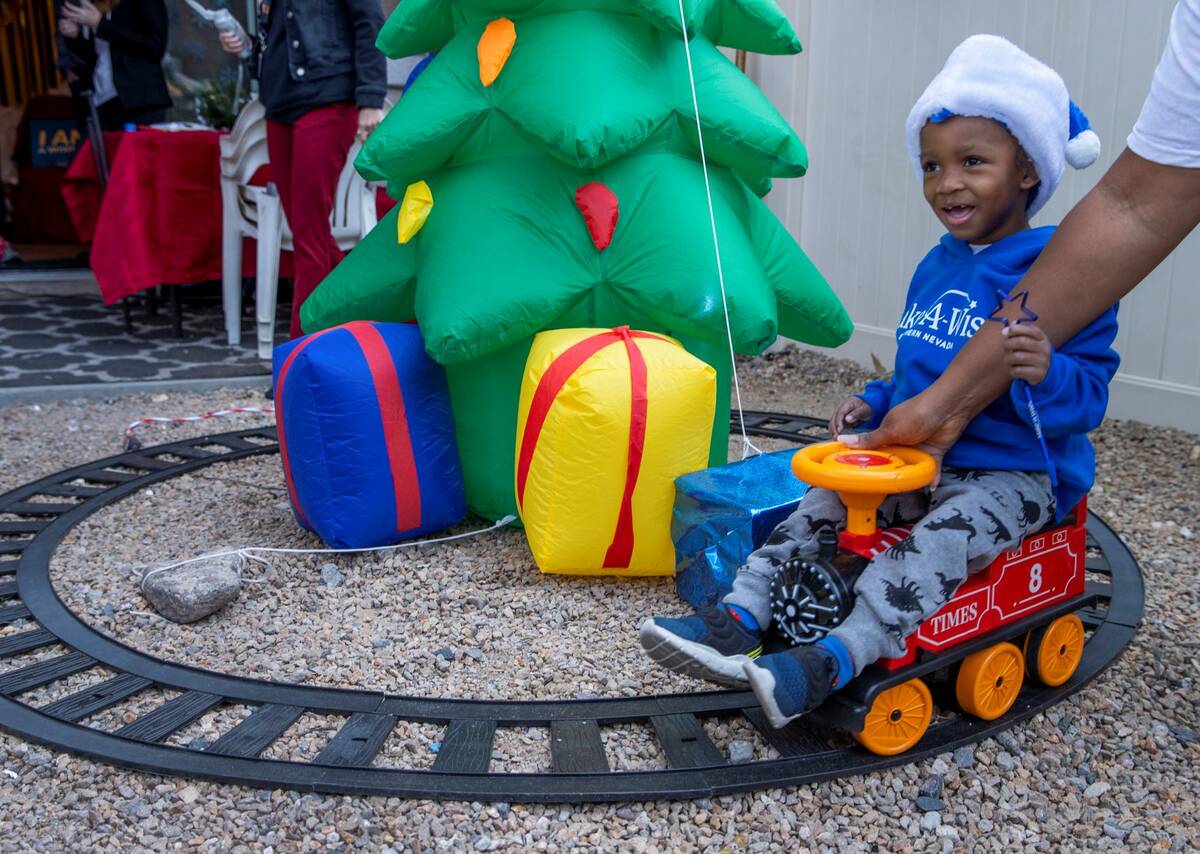 Aayden Hobbs, 3, a heart transplant recipient, checks out a tree and electric train on the trac ...