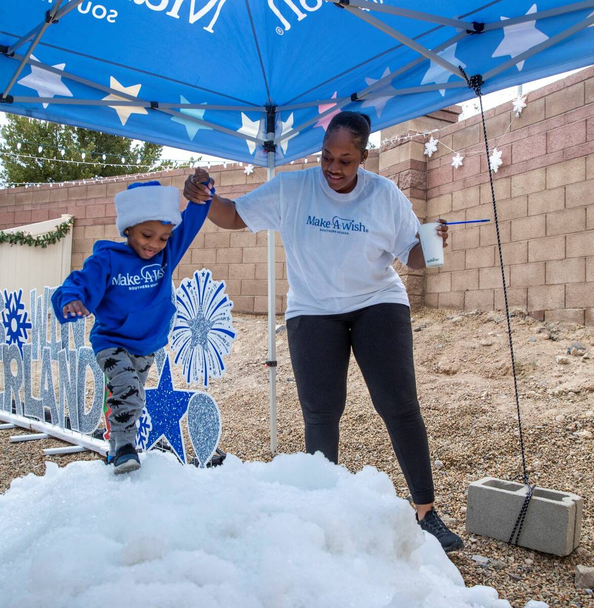 Aayden Hobbs, 3, a heart transplant recipient, climbs atop a snow mountain with the help of his ...