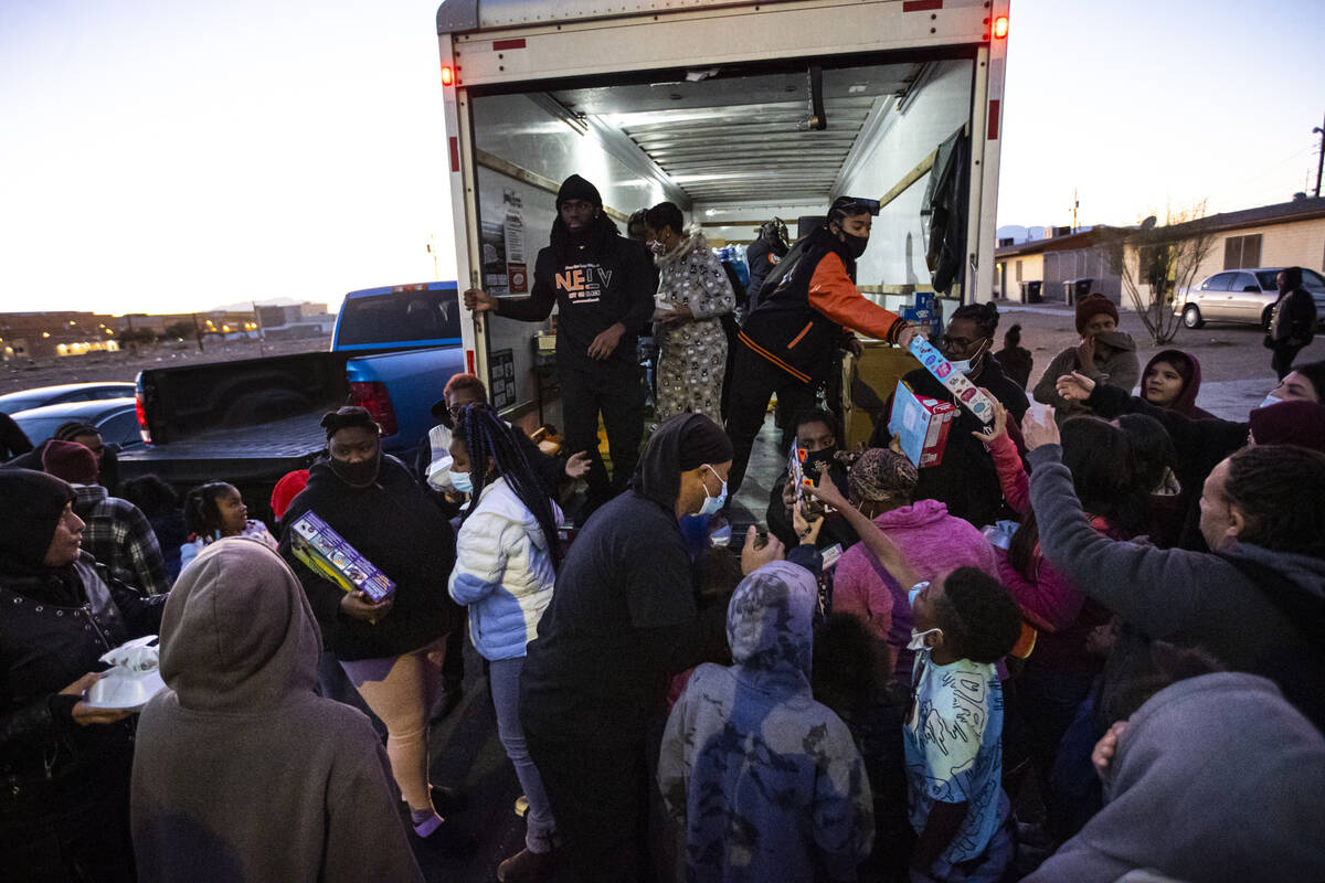 Members of New Era Nation and the New Era Las Vegas chapter hand out toys and hot meals during ...