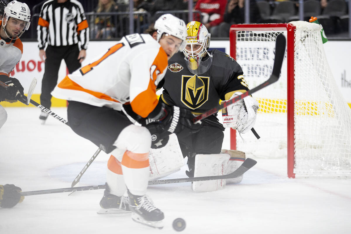 Golden Knights goaltender Laurent Brossoit (39) eyes the puck as Flyers right wing Travis Konec ...