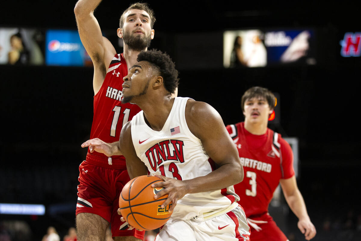 UNLV Rebels guard Bryce Hamilton (13) looks to shoot while Hartford Hawks guard Briggs McClain ...