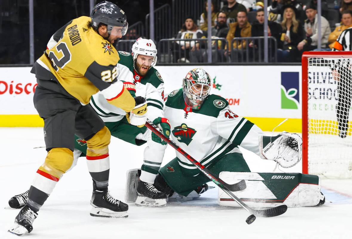 Golden Knights center Michael Amadio (22) attempts a shot as Minnesota Wild defenseman Alex Gol ...