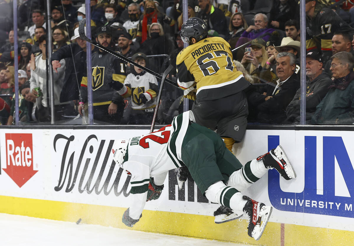 Minnesota Wild defenseman Matt Dumba (24) gets tripped up against Golden Knights left wing Max ...