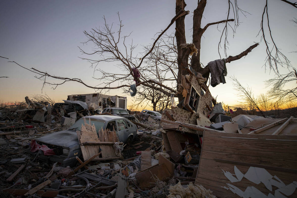 A car sits among the remains of a destroyed house after a tornado in Dawson Springs, Ky., Sunda ...