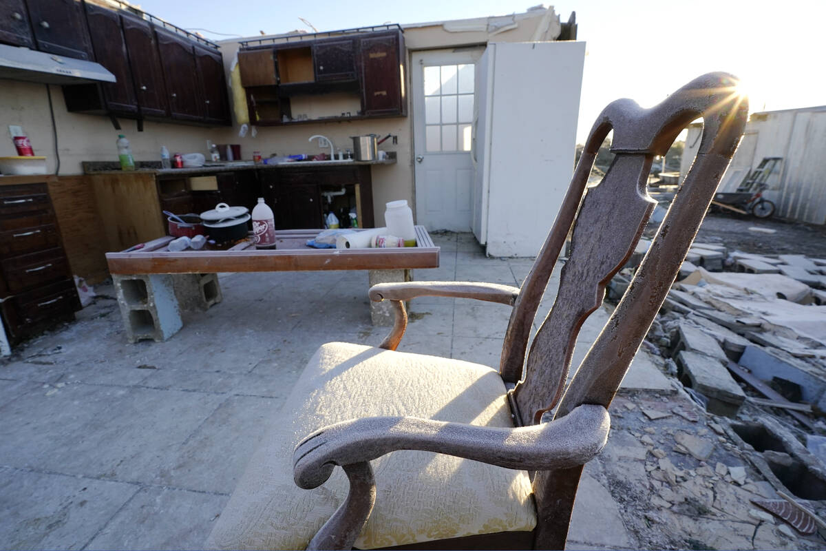 Early morning frost covers a chair sitting in a destroyed home Sunday, Dec. 12, 2021, in Mayfie ...