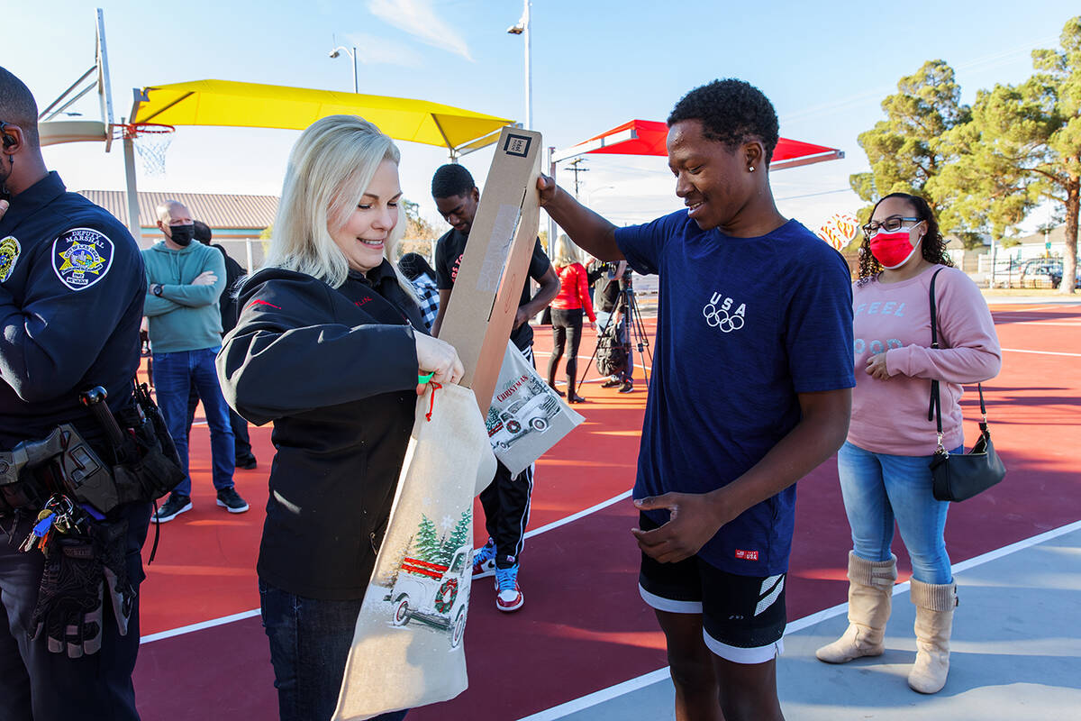 Danielle Bisterfeldt, senior vice president of marketing for Summerlin, assists laptop recipien ...