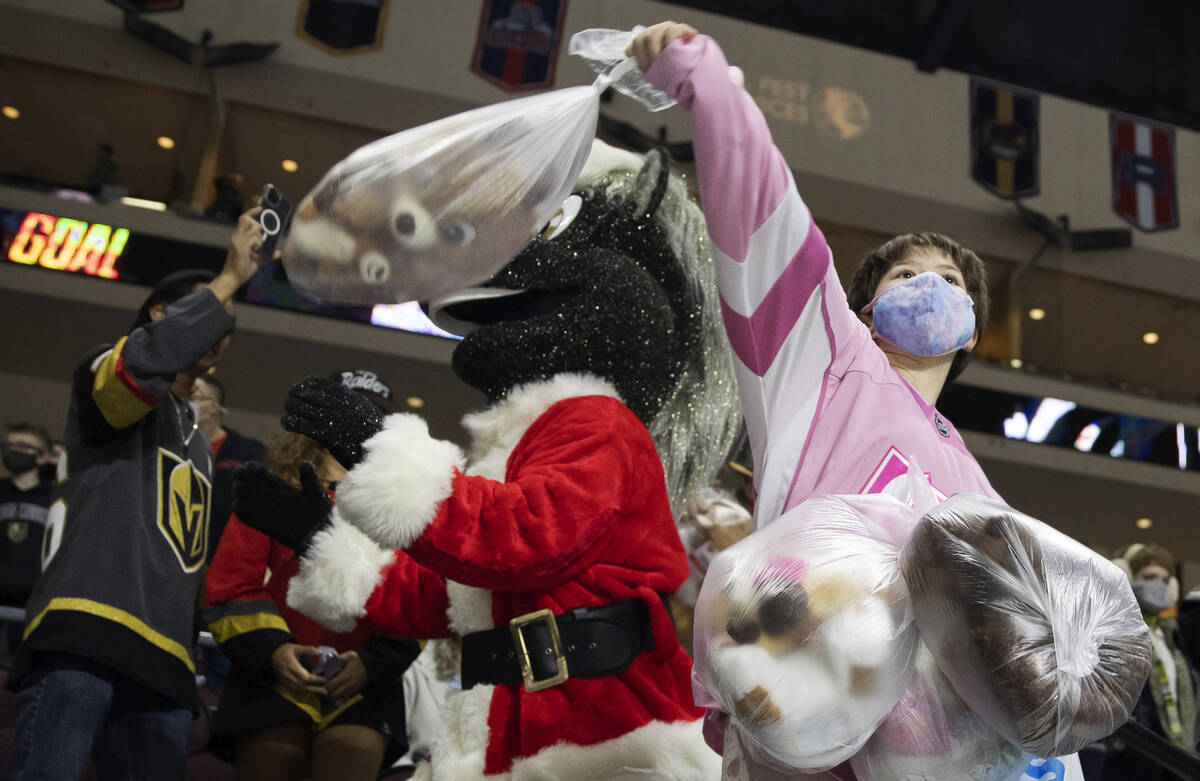 Jacqueline Taylor, 10, throws bags of teddy bears on the ice after the first Silver Knights goa ...