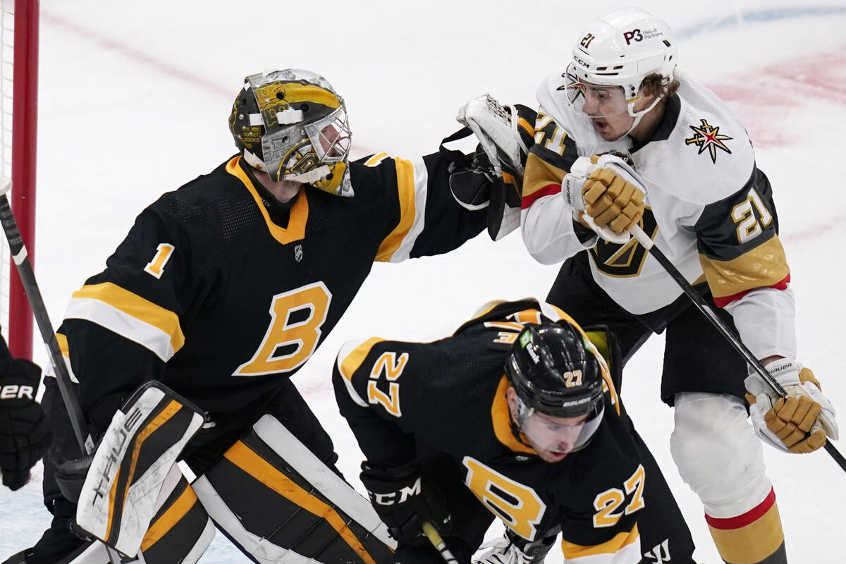 Boston Bruins goaltender Jeremy Swayman (1) pushes away Vegas Golden Knights center Brett Howde ...