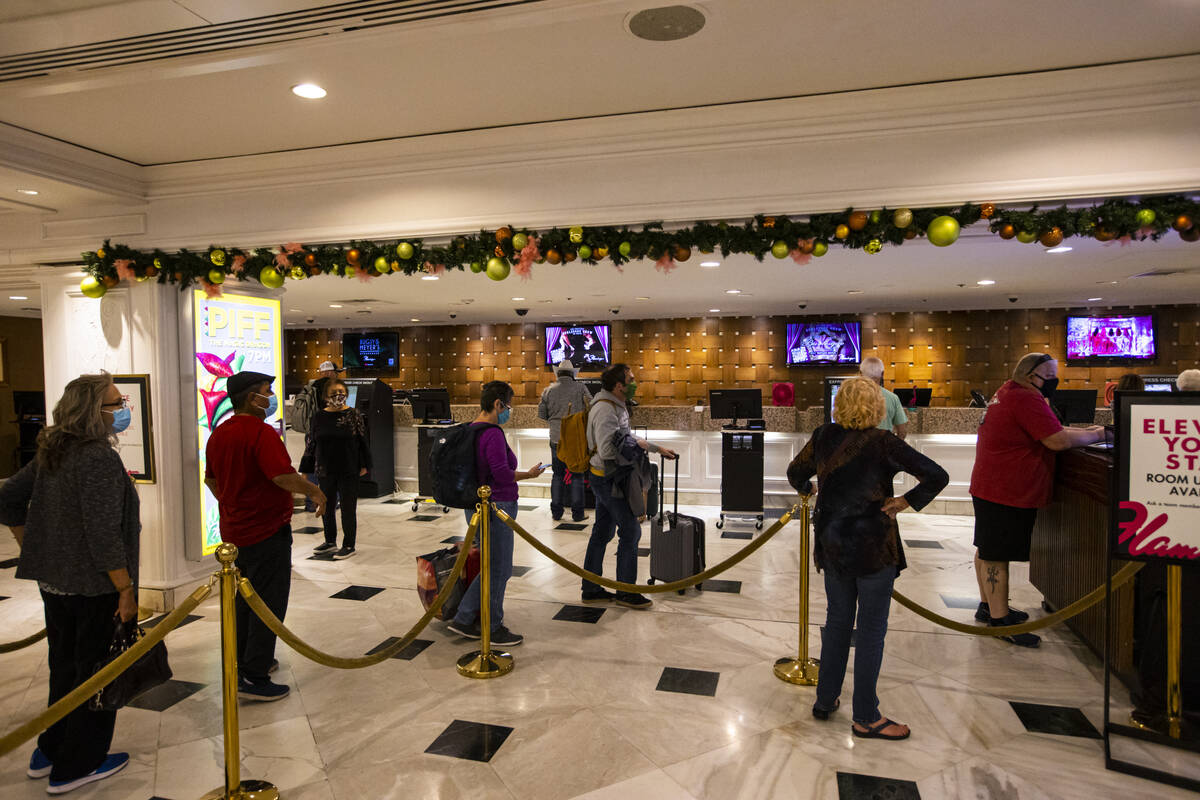 Hotel guests line up to check in at the Flamingo in Las Vegas on Wednesday, Dec. 8, 2021. (Chas ...