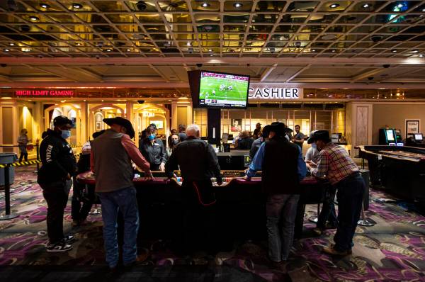 People play at a craps table at the Flamingo in Las Vegas on Wednesday, Dec. 8, 2021. (Chase St ...